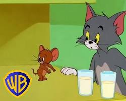 トムとジェリー。牛乳のグラスを挟んで向き合う猫とネズミ